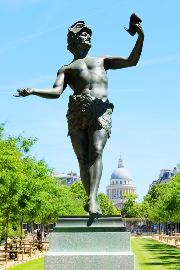 A statue of Pan in the Luxembourg Gardens with the dome of the Panthéon visible in the background.